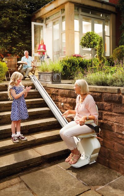 Woman enjoying the outdoors on her stairlift from acorn stairlifts